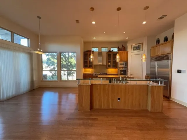 a living room with stainless steel appliances furniture and a wooden floor