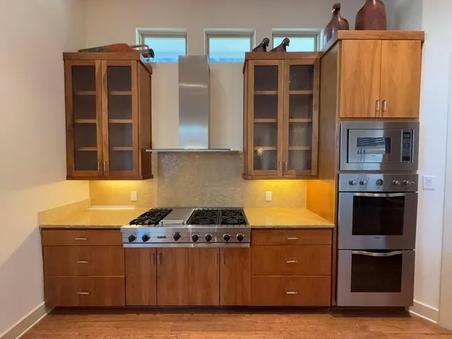 a kitchen with stainless steel appliances kitchen island wooden cabinets and granite counter tops