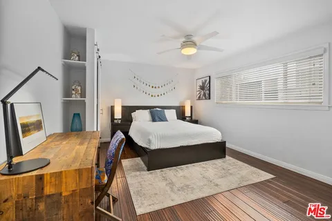 a bedroom with a bed and wooden floor