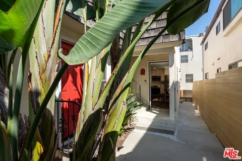 a front view of a house with plants and lake view