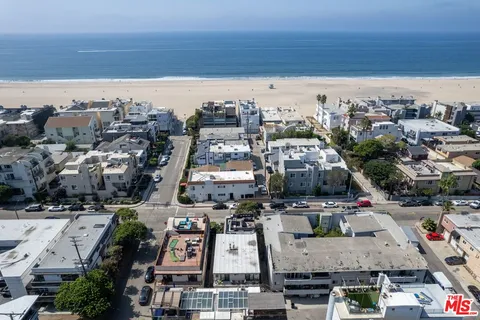 an aerial view of a city with ocean view in back
