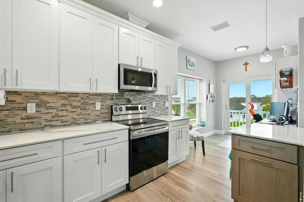 3073 Painters Walk Flagler Beach, FL 32136 - Photo 16 of 66 a kitchen with a sink stove and microwave