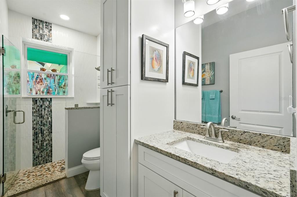 3073 Painters Walk Flagler Beach, FL 32136 - Photo 48 of 66 a bathroom with a granite countertop sink a toilet and a large mirror
