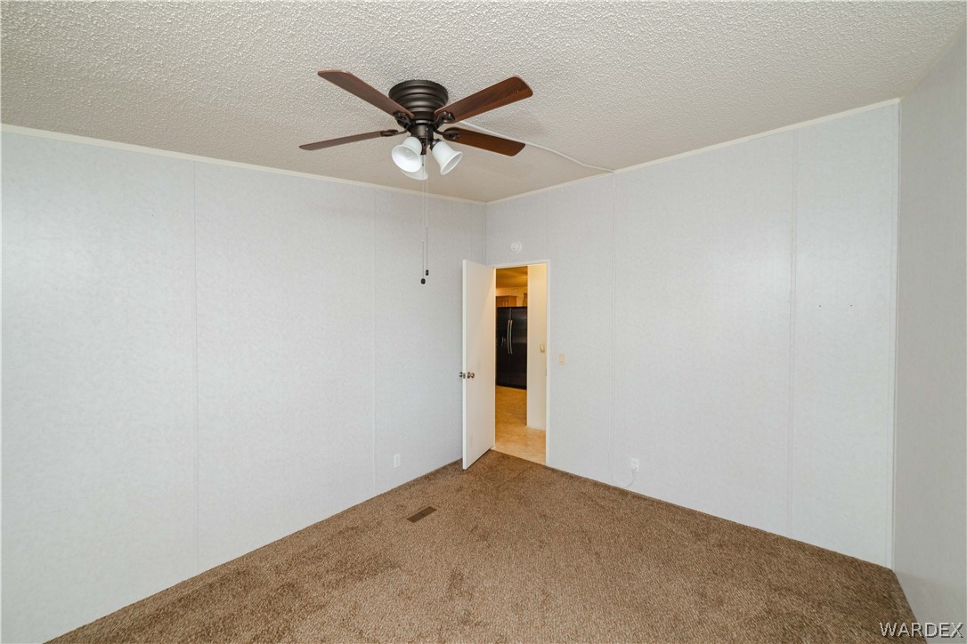 3003 Hualapai Mountain Road Kingman, AZ 86401 - Photo 24 of 49 an empty room with a ceiling fan and carpet