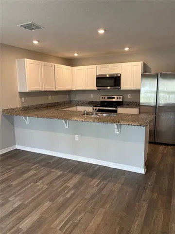 a kitchen with stainless steel appliances granite countertop a stove a sink and a refrigerator