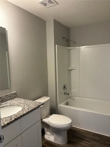 a bathroom with a granite countertop bathtub toilet and sink