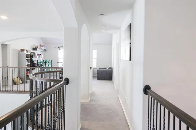 a view of a hallway with a livingroom and a chandelier