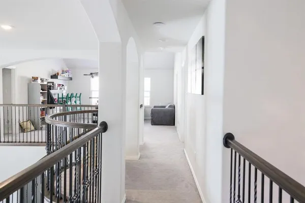 a view of a hallway with a livingroom and a chandelier