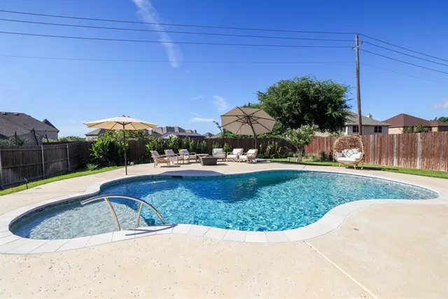 a view of a swimming pool with a patio and a yard