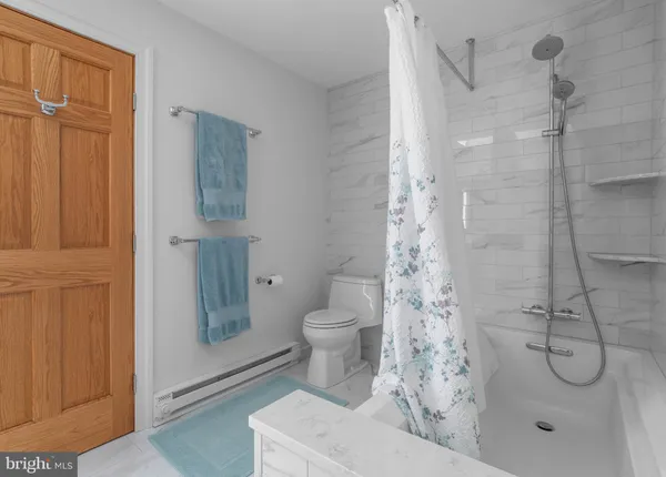 a bathroom with a shower a toilet and a sink