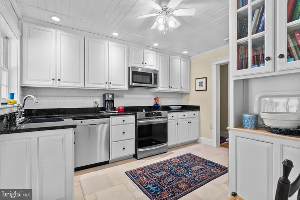 a kitchen with stainless steel appliances granite countertop a stove sink and cabinets