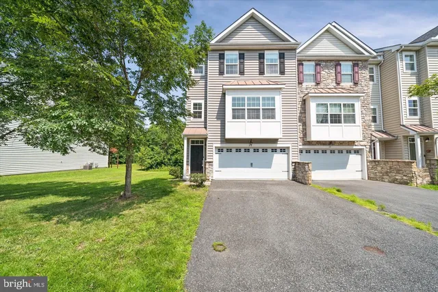 a front view of a house with a yard and trees