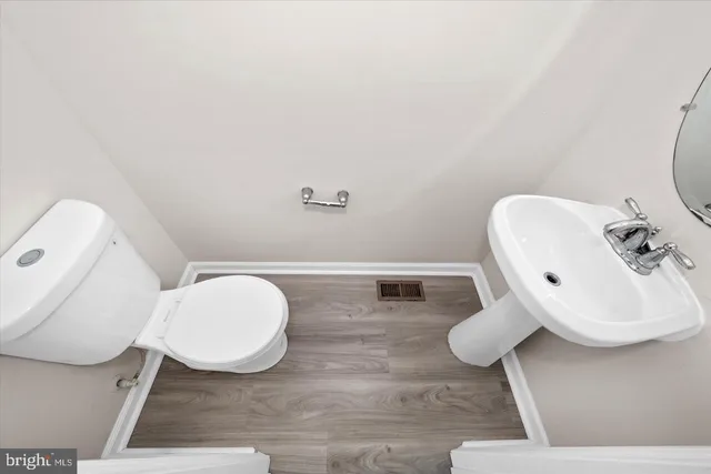 a bathroom with a toilet sink and mirror