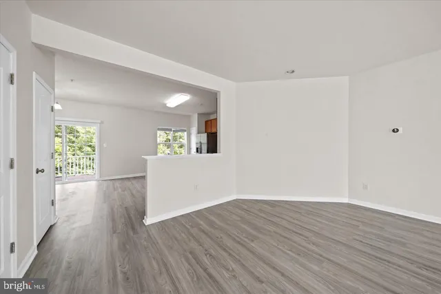 a view of a big room with wooden floor and windows