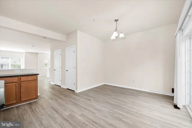 a view of a kitchen with wooden floor and a window