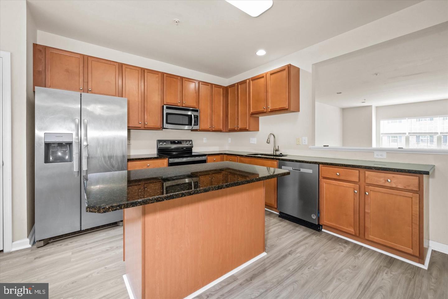 26 Munro Road Newark, DE 19711 - Photo 10 of 22 a kitchen with stainless steel appliances granite countertop a refrigerator a sink dishwasher a stove with wooden cabinets and wooden floor