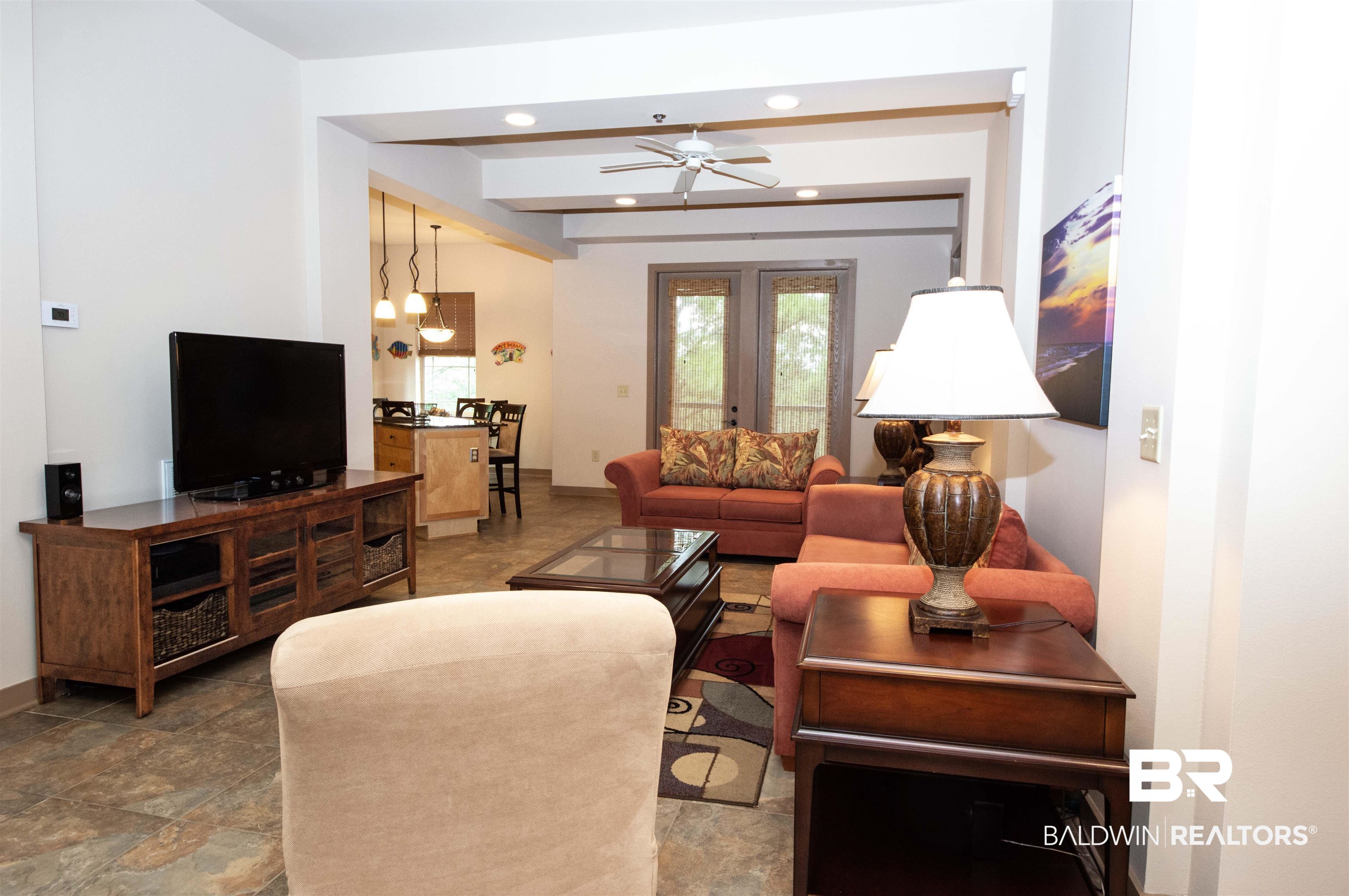 1430 Regency Road, Unit 301C Gulf Shores, AL 36542 - Photo 17 of 22 Tiled living room with french doors, ceiling fan, and beam ceiling