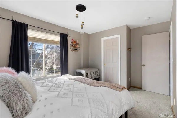 a bedroom with a bed and a large window