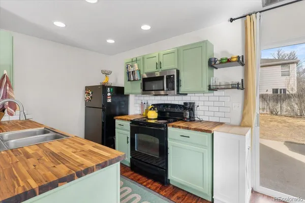 a kitchen with stainless steel appliances kitchen island granite countertop a refrigerator a stove and a sink