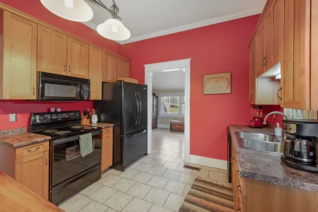 a kitchen with stainless steel appliances granite countertop a stove refrigerator sink and microwave