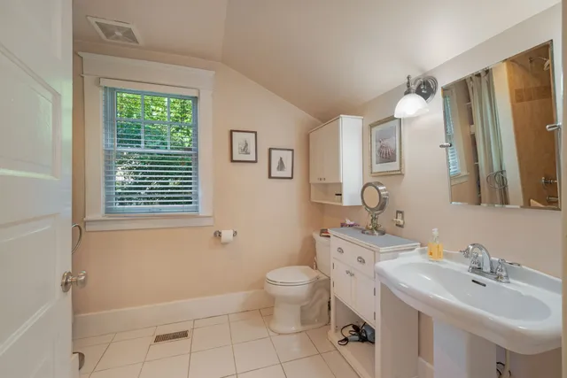 a bathroom with a sink a toilet and a mirror