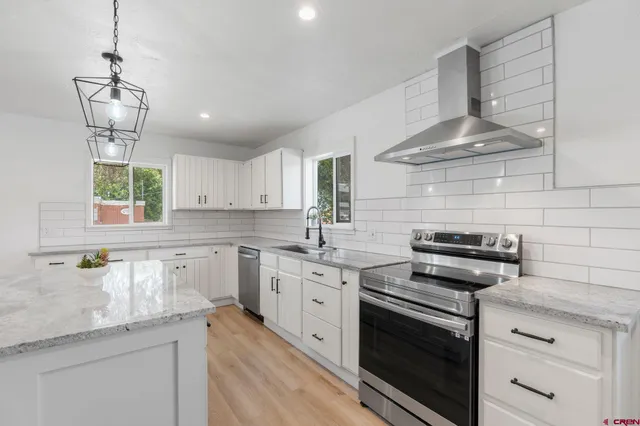 a kitchen with stainless steel appliances a stove sink and cabinets