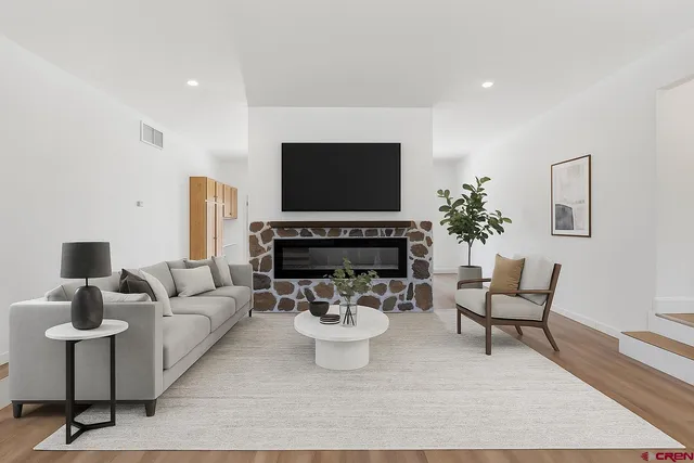 a living room with furniture a flat screen tv and a potted plant