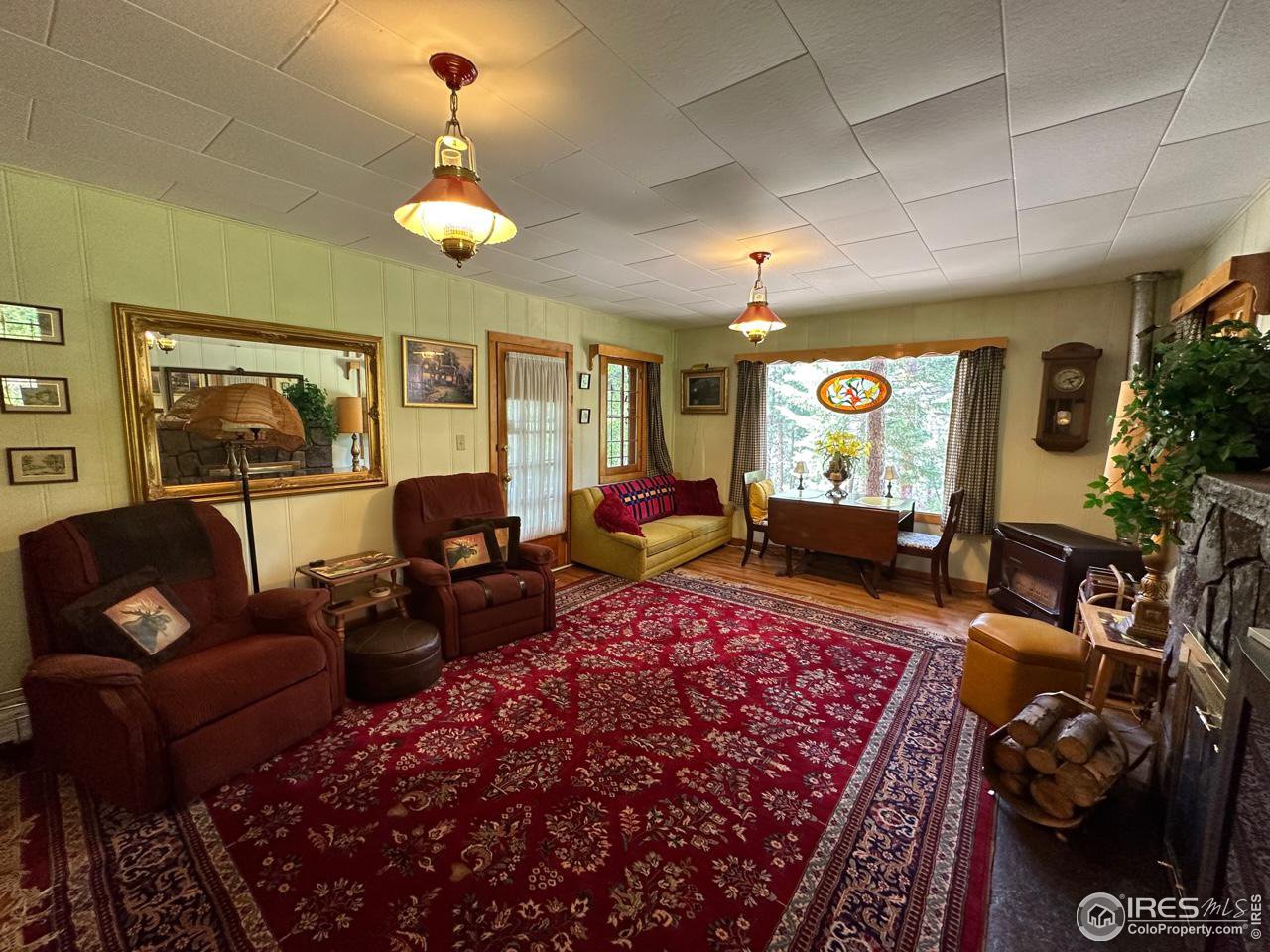 414 Riverside Drive Lyons, CO 80540 - Photo 13 of 23 a living room with furniture a chandelier and a rug