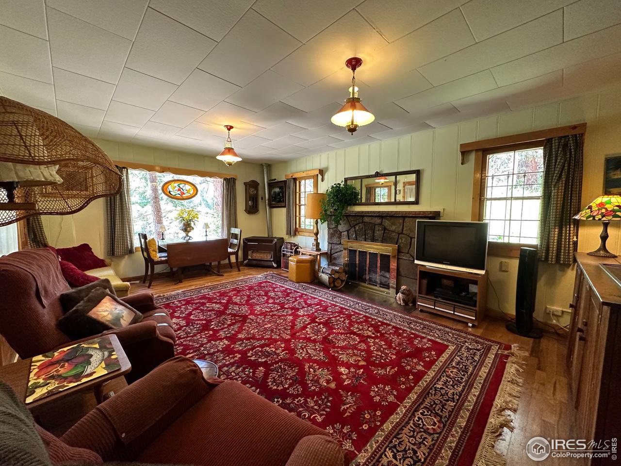 414 Riverside Drive Lyons, CO 80540 - Photo 16 of 23 a living room with furniture a fireplace and a flat screen tv
