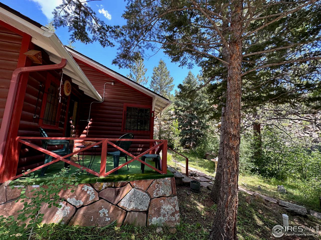 414 Riverside Drive Lyons, CO 80540 - Photo 5 of 23 a backyard of a house with table and chairs under an umbrella
