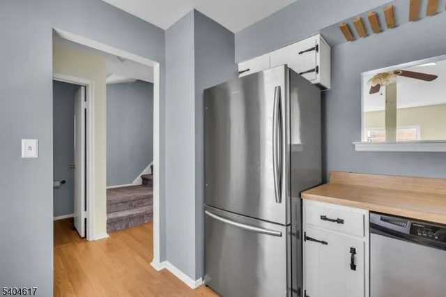 a view of kitchen with refrigerator and wooden floor