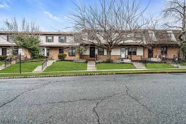a view of a big house with a big yard and large trees