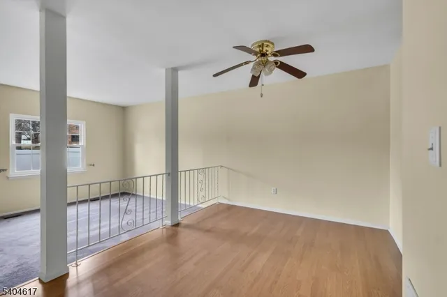 a view of a room with a ceiling fan and a window