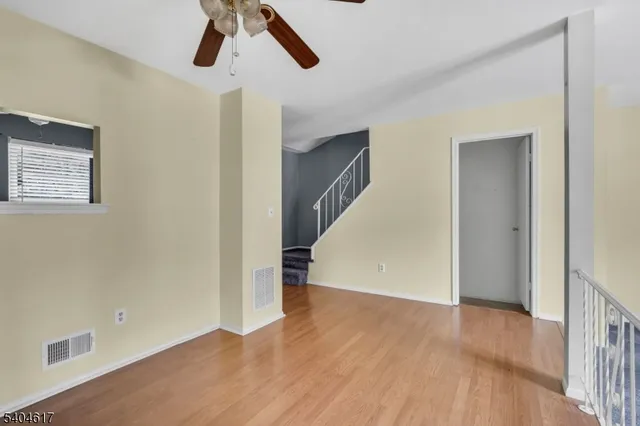 a view of a hallway with wooden floor and entryway
