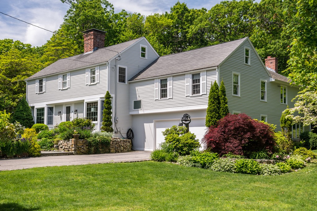 a front view of a house with a yard and potted plants