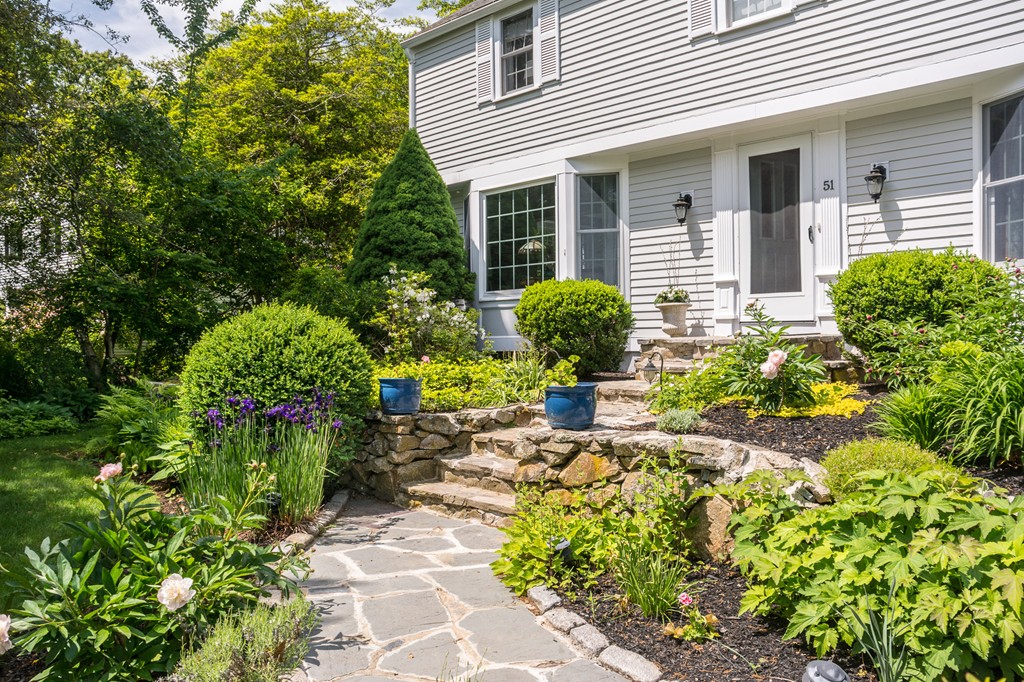 51 Deep Run Cohasset, MA 02025 - Photo 7 of 30 a front view of a house with a yard and a garden