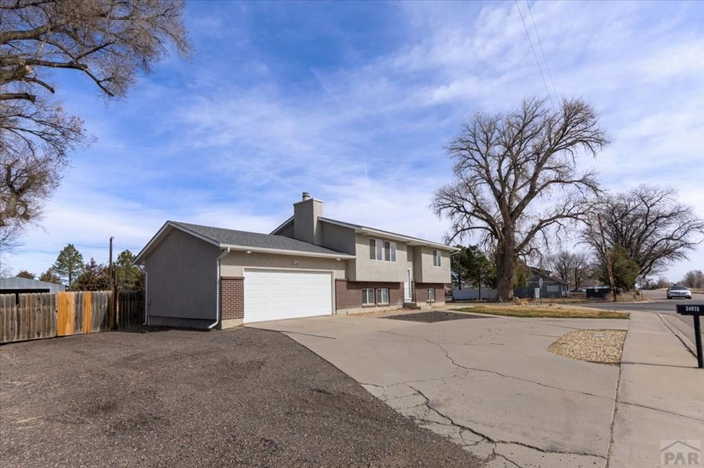 24975 S Road Pueblo, CO 81006 - Photo 36 of 43 a front view of a house with a yard and garage