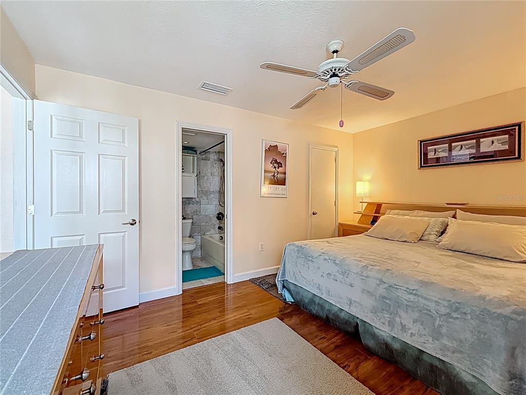 230 Medallion Boulevard, Unit G Madeira Beach, FL 33708 - Photo 19 of 38 a bedroom with a bed and wooden floor