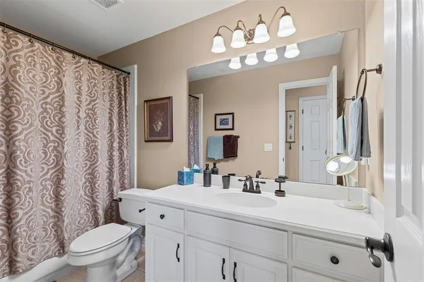 a bathroom with a sink vanity mirror and toilet