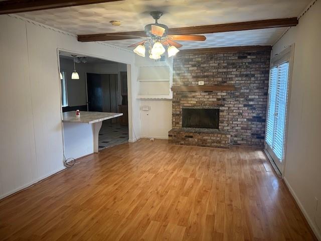 7152 Indian Ridge Trail Dallas, TX 75232 - Photo 3 of 17 an empty room with wooden floor a fireplace and entryway