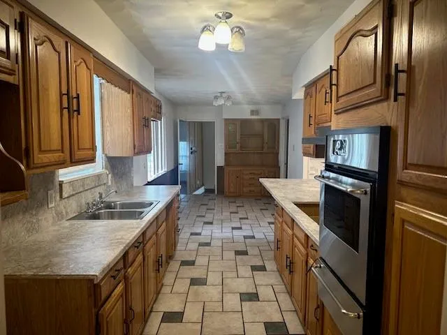 a kitchen with granite countertop stainless steel appliances a sink stove and refrigerator