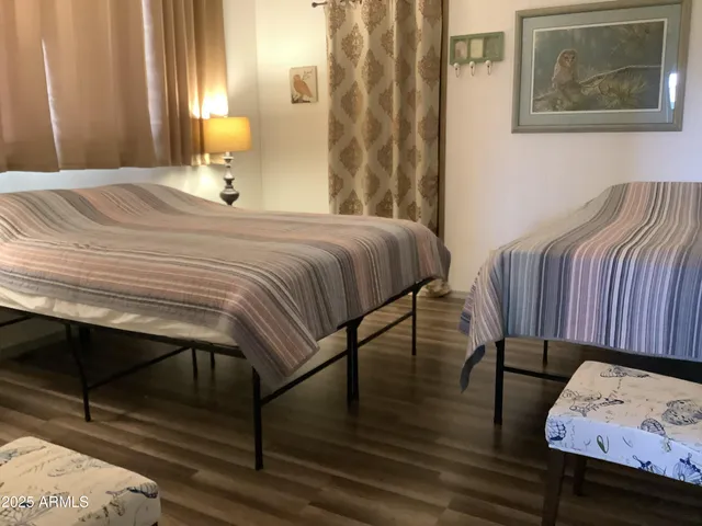 a bedroom with bed and wooden floor