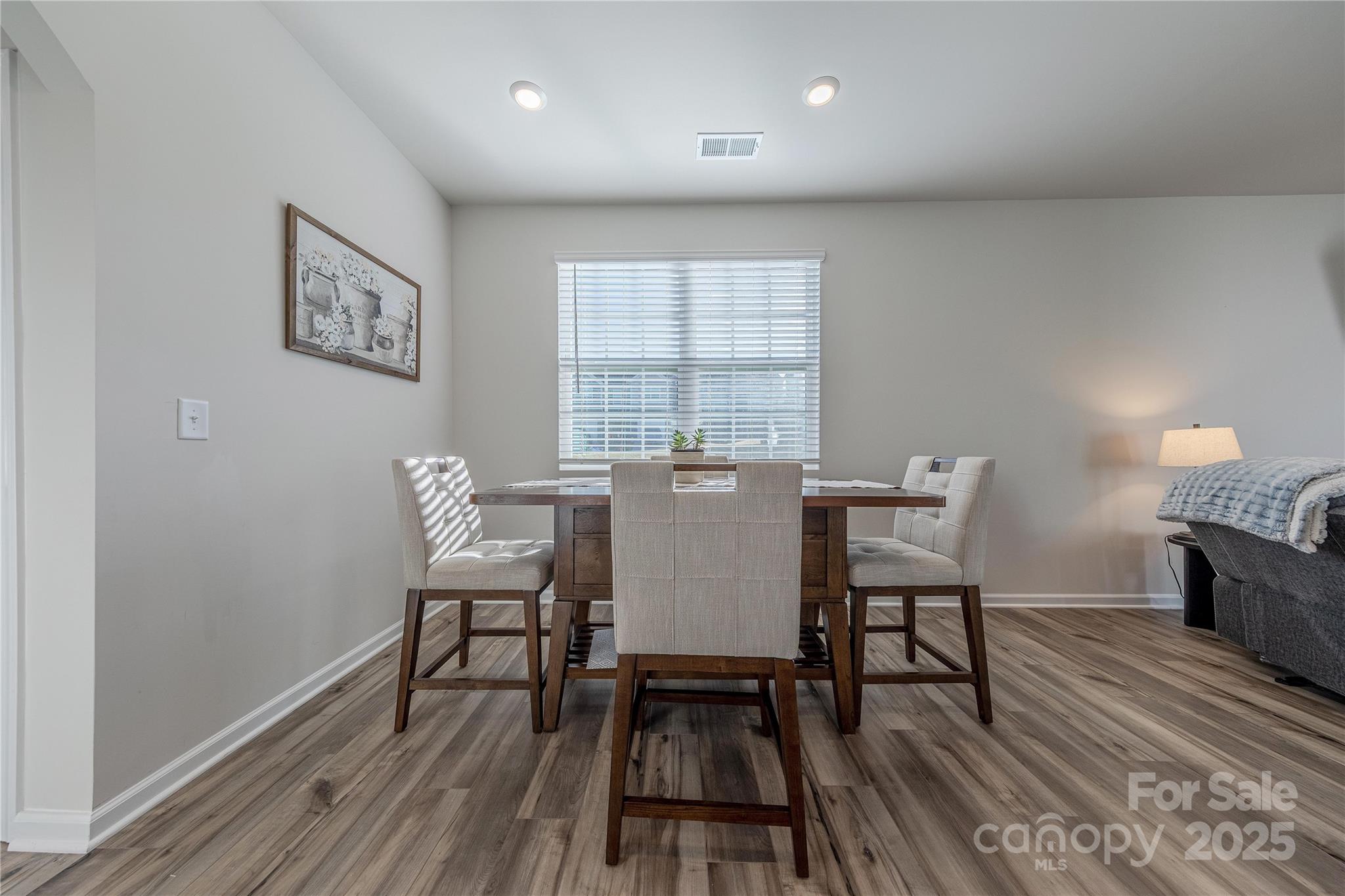 8007 Scarlet Maple Lane Tega Cay, SC 29708 - Photo 11 of 24 a view of a dining room with furniture window and wooden floor