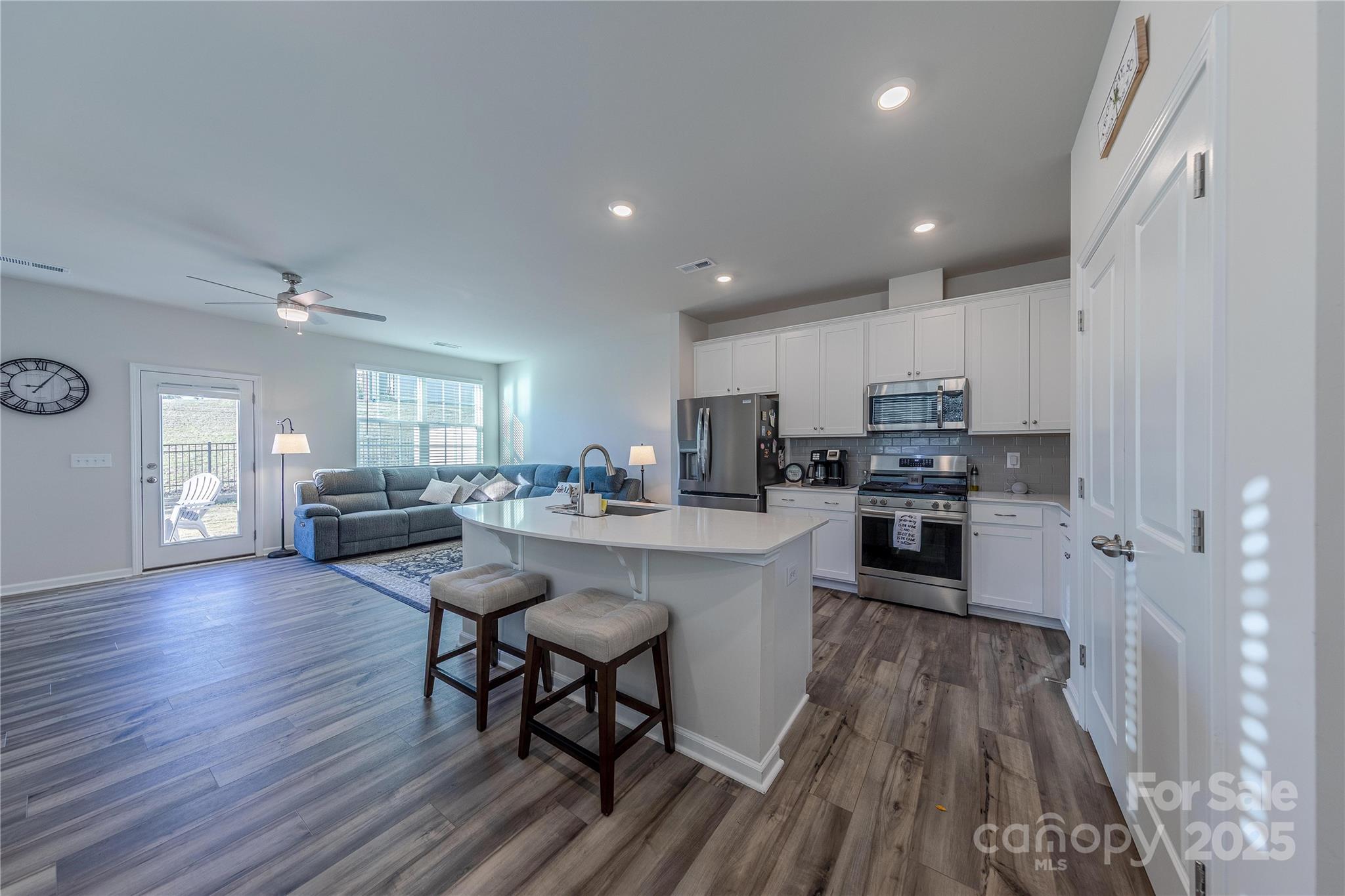 8007 Scarlet Maple Lane Tega Cay, SC 29708 - Photo 7 of 24 a kitchen with stainless steel appliances a dining table chairs stove refrigerator and cabinets