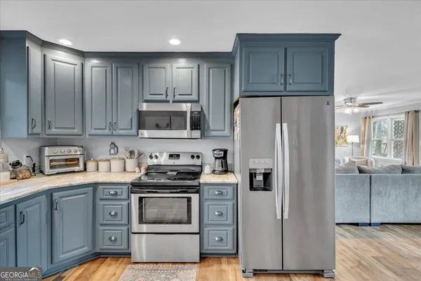 a kitchen with stainless steel appliances granite countertop a refrigerator stove and sink