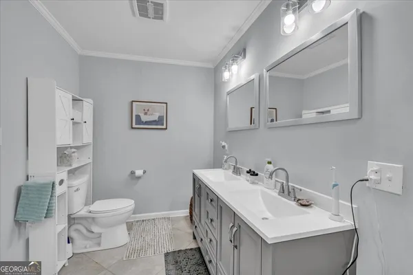a bathroom with a double vanity sink mirror and toilet