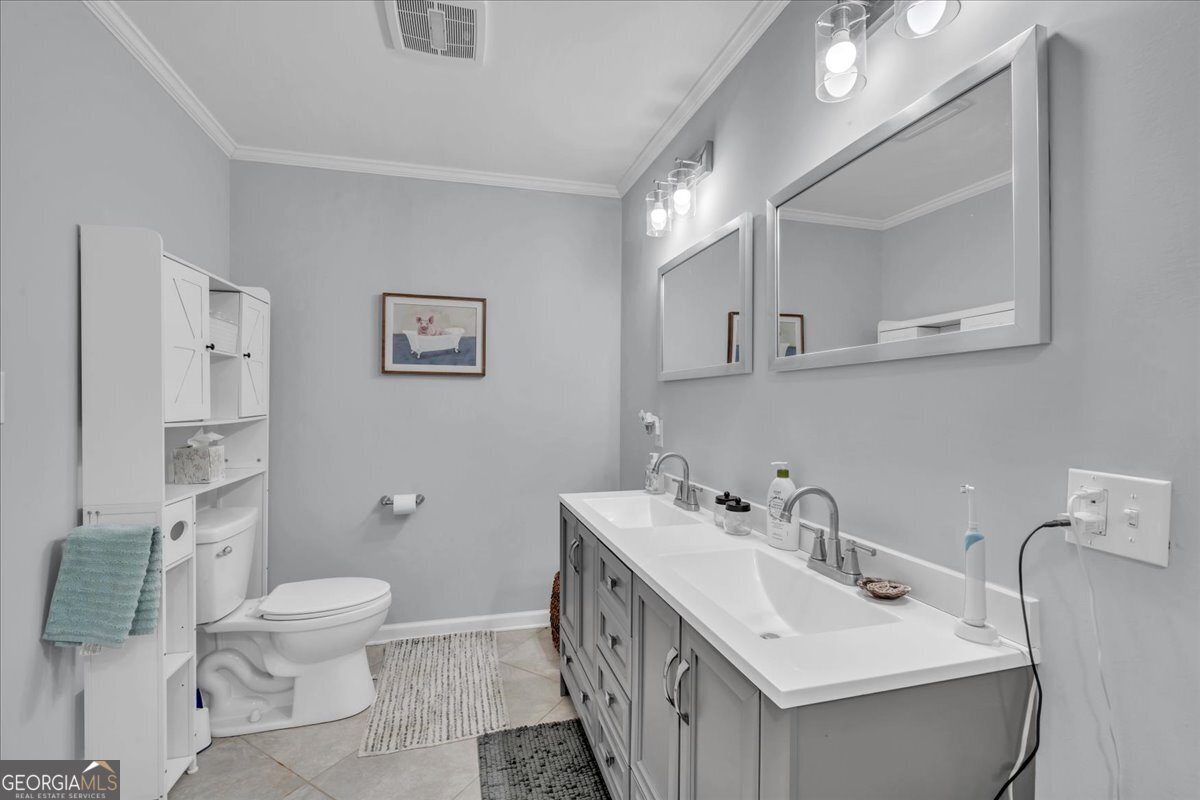 480 Country Club Road Dublin, GA 31021 - Photo 22 of 42 a bathroom with a double vanity sink mirror and toilet