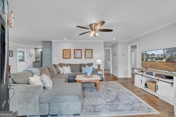 a living room with furniture a table and wooden floor