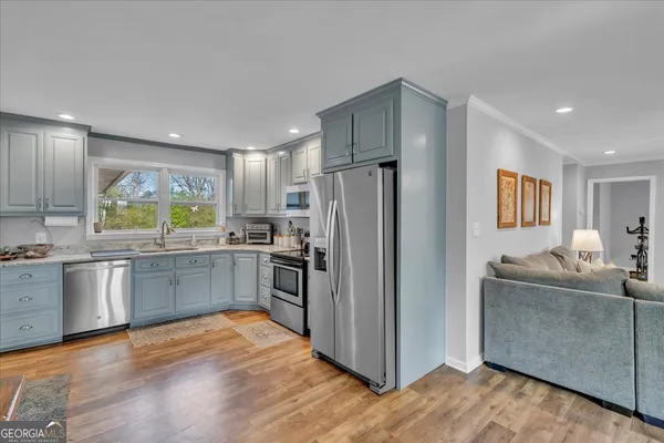 a kitchen with stainless steel appliances granite countertop a refrigerator and a sink