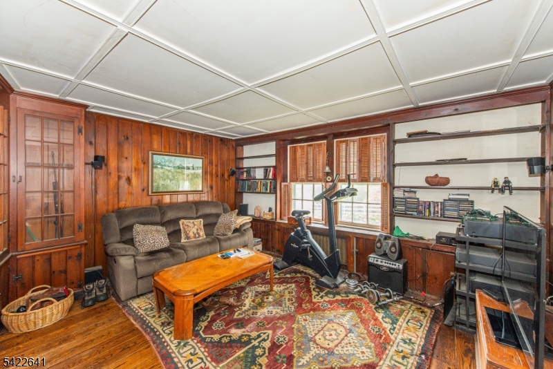 570 Mine Brook Road Bernardsville, NJ 07924 - Photo 13 of 38 a living room with furniture a flat screen tv and a floor to ceiling window